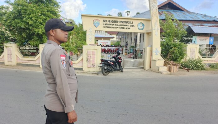 PENGABDIAN DI TAPAL BATAS NKRI: AIPDA HENDRA KIKILAITETY SETIA TEMANI SISWA MENYEBERANGI JALAN